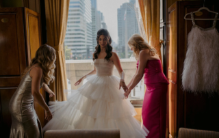 woman getting dressed in wedding gown
