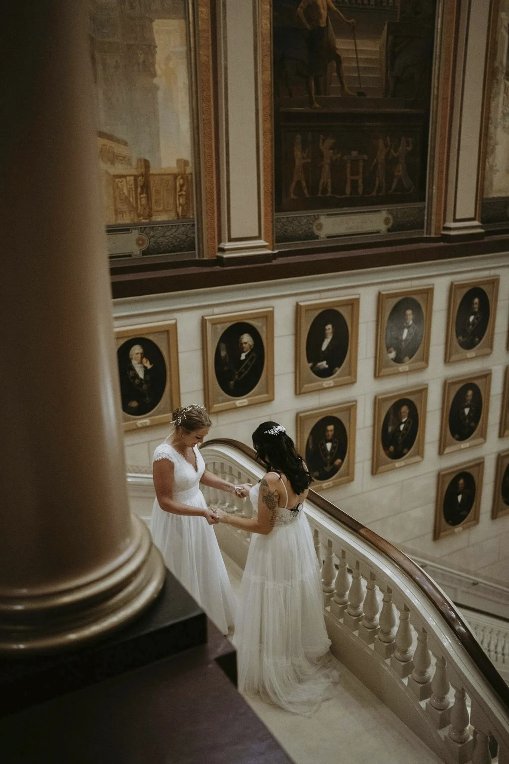 Brides holding hands on balcony