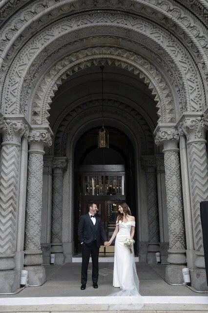 Bride and groom standing together in front of elaborate entryway