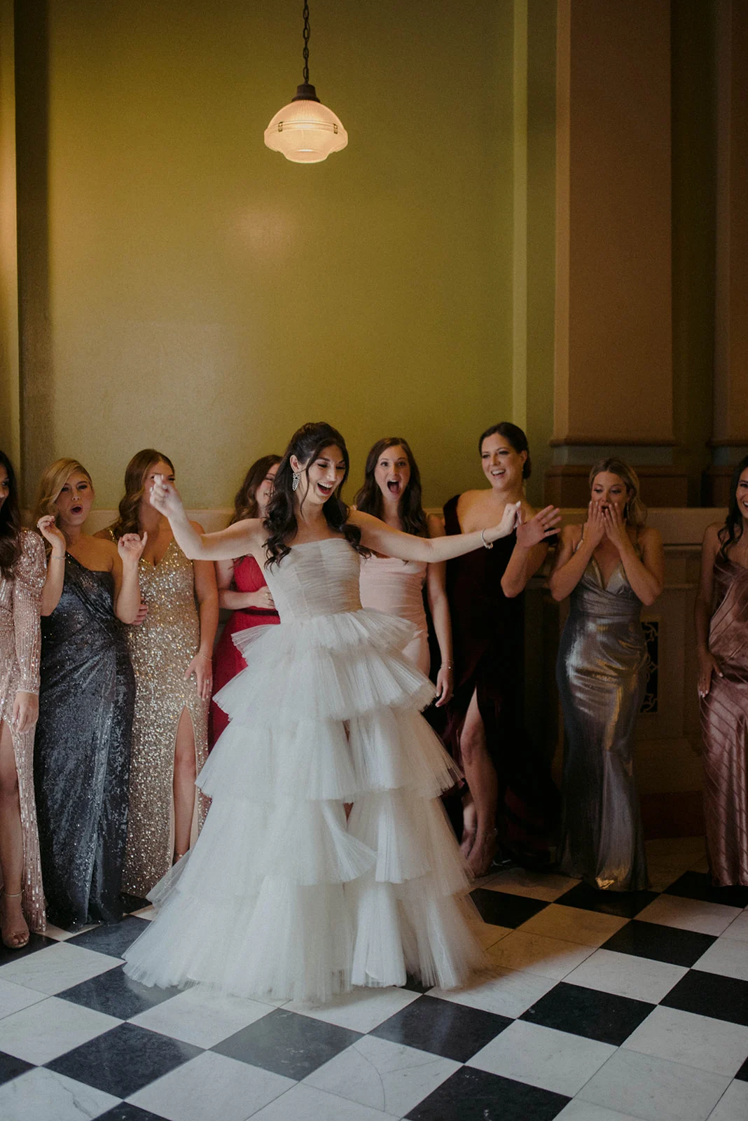 CASEY & TREVOR Bride showing off ruffled dress to bridal party