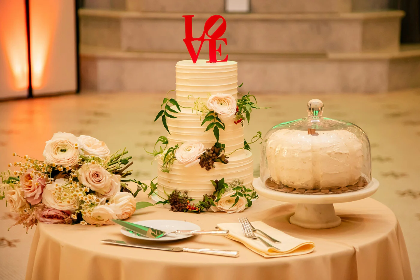 3235236-sm Table with tiered cake with "LOVE" decorative topper, pastry and flowers