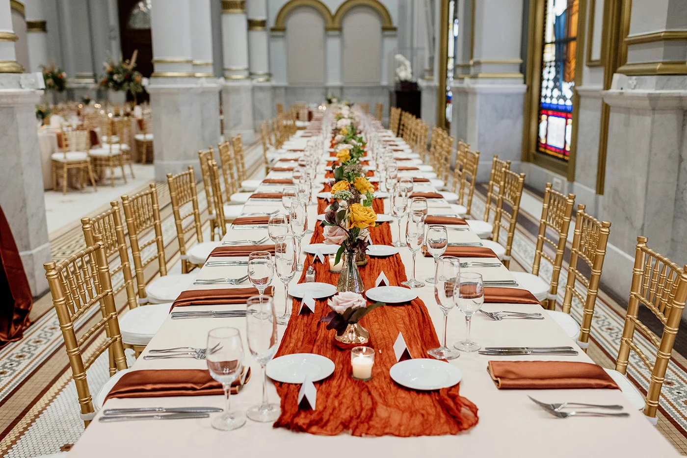 3237911-sm Long table set for dinner with white table cloth and orange table runner