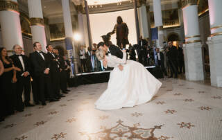 Bride and groom kissing on a dance floor.