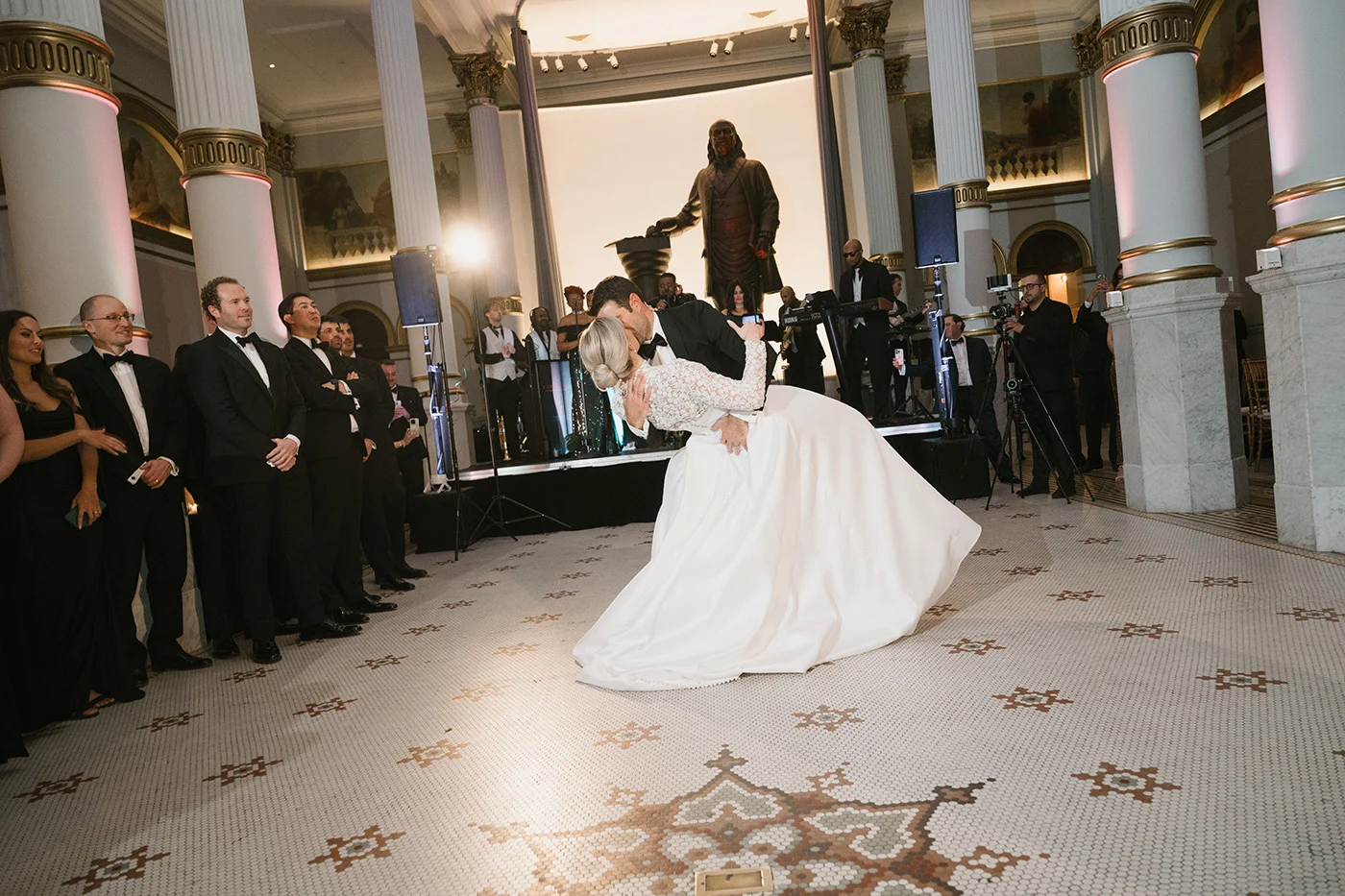 12_31_24_J_M_Wedding_-1588 Bride and groom kissing on a dance floor.
