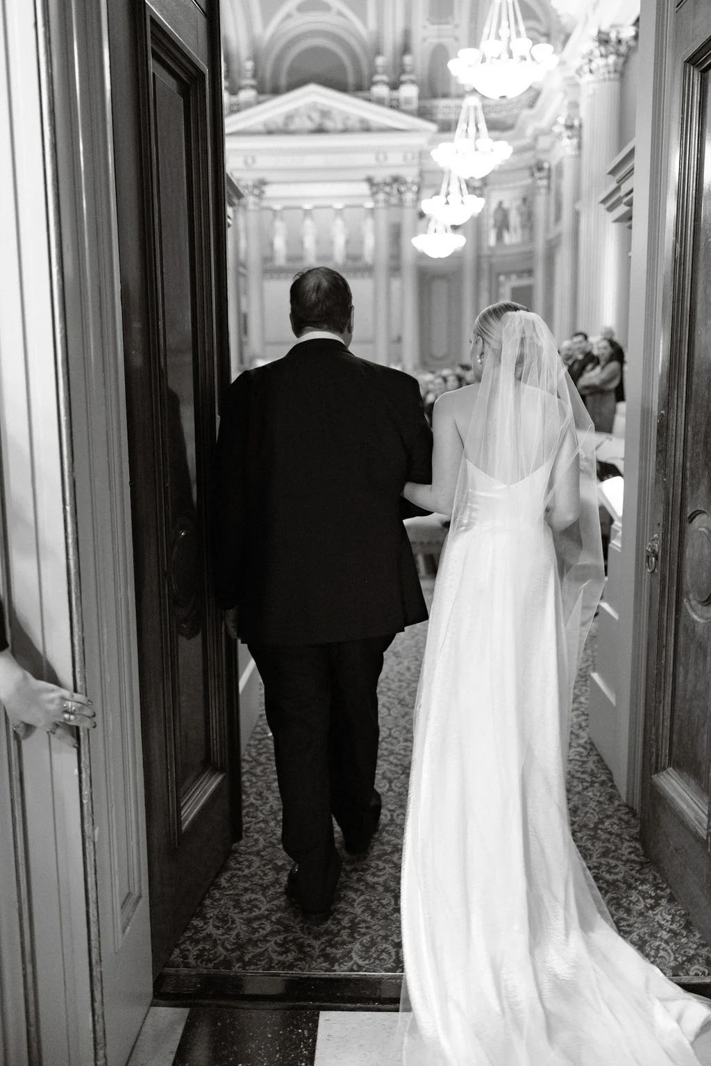 Flynn_Joe_Wedding_0811 Bride and father walking together through doorway while facing away from the camera.