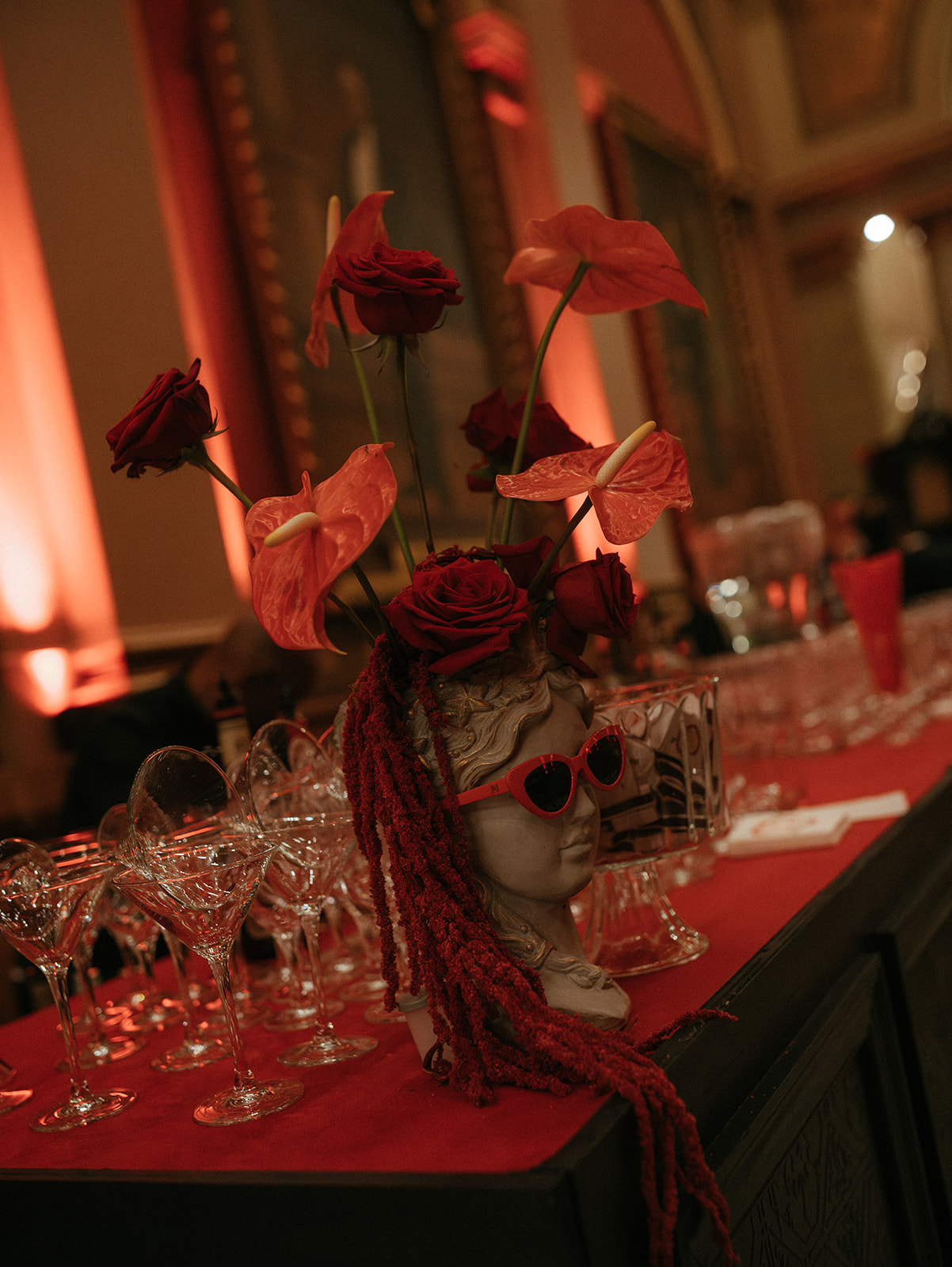 Closeup of red flowers set on a red tablecloth.