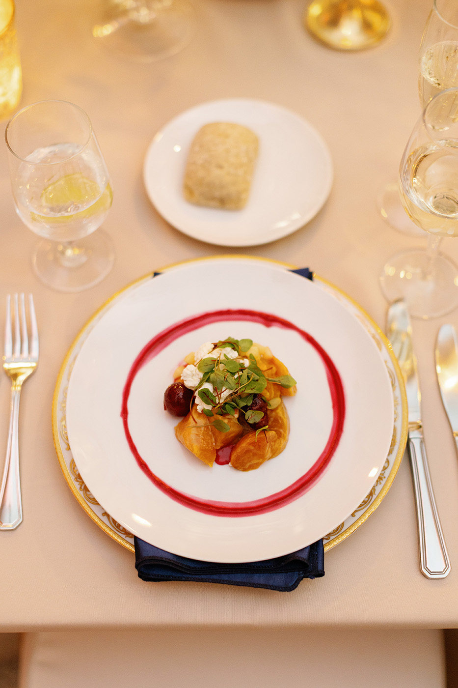 Dinner prepared with garnish on an ornate plate setting.