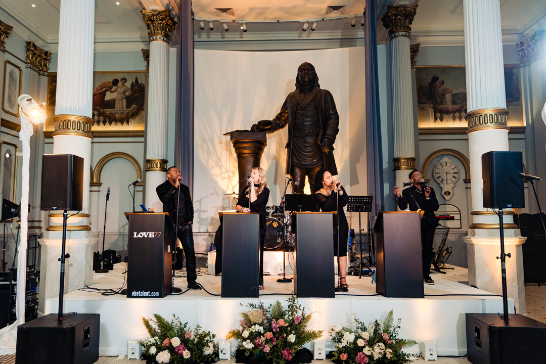 Ralph Deal Photography (1) Four singers at podiums in front of large, bronze Benjamin Franklin statue.