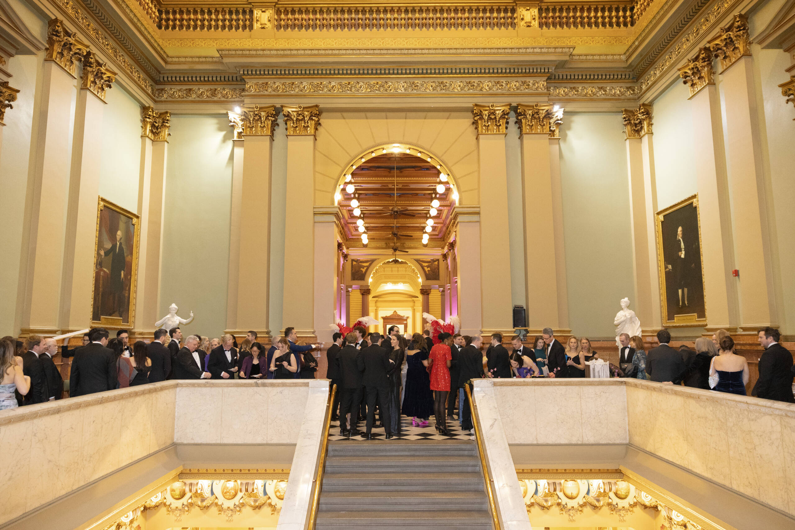 Daria M. Photography 2 Group dressed in formal attire gathered around a large staircase.