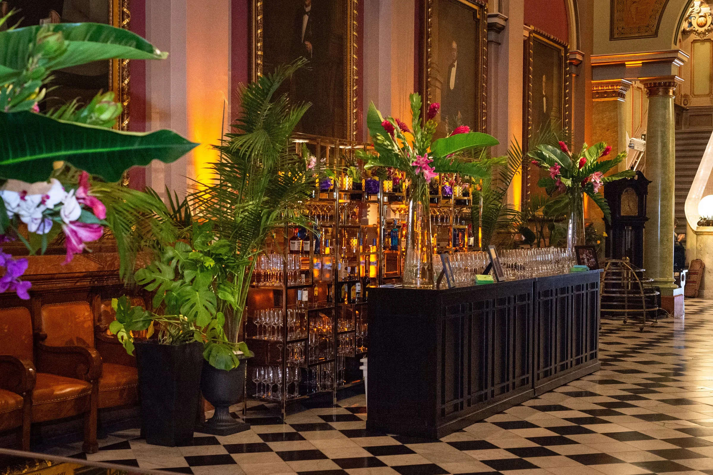 photo-fbf1a843-e695-4e81-81a8-6b1ceb893fd0 (1) A fully stocked bar with lush botanical decor surrounding it.